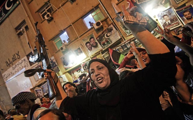 الصورة: سيدة ليبية تحمل بندقية احتفالا بتحرير طرابلس. اف ب