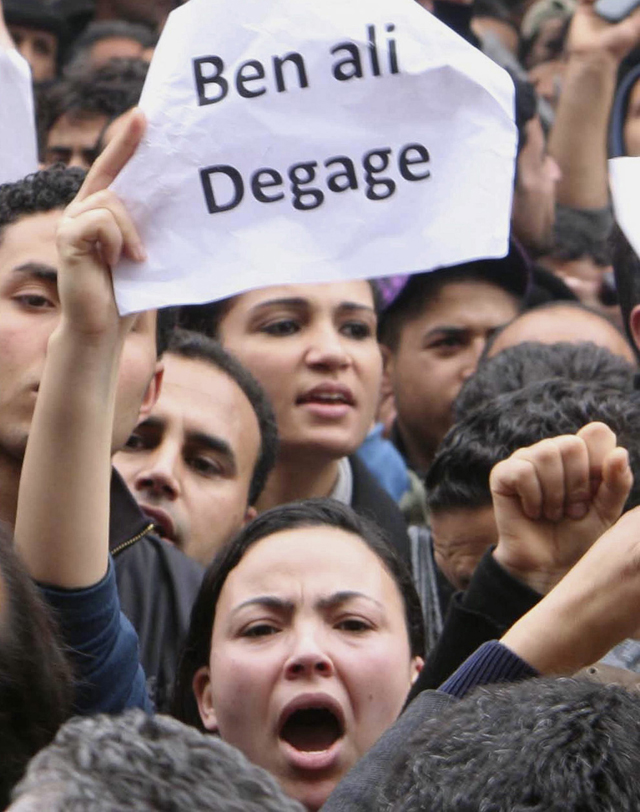 الصورة: متظاهرة تحمل لافتتة كتب عليها "أخرج يا بن علي"