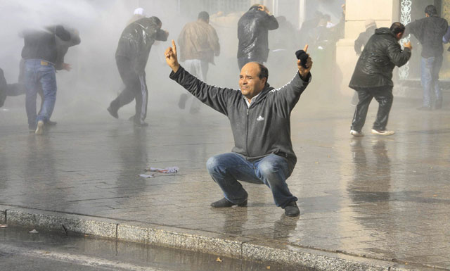 الصورة: متظاهر يتصدى لخراطيم المياه التي استخدمتها الشرطة لتفرقة المتظاهرين