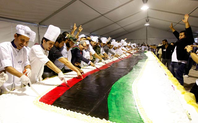الصورة: وزير العدل محمد العلاقي يقطع كعكة احتفالا بتحرير ليبيا. طرابلس - رويترز