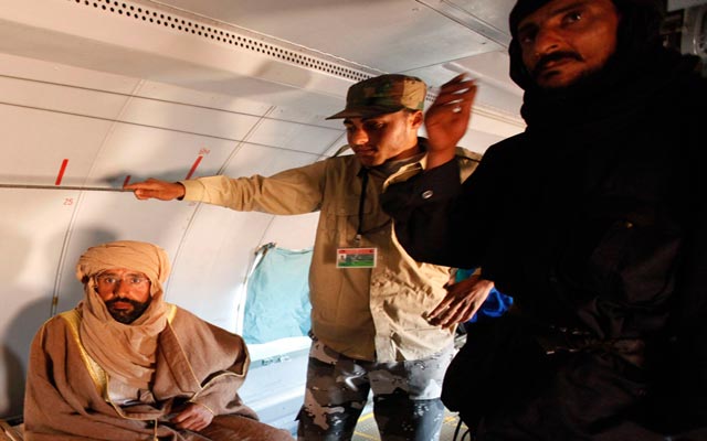 الصورة: سيف الإسلام القذافي في الطائرة نحو الزنتان بعد إلقاء القبض عليه في 19 نوفمبر. رويترز