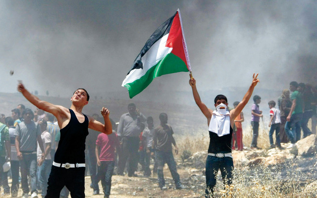 "فلسطينيون وسط دخان خلال المواجهات شرق نابلس (أ.ف.ب)"