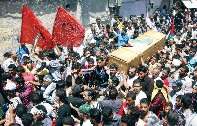 "تشييع جثمان أحد الشهداء في مخيم للاجئين الفلسطينيين قرب دمشق (أ.ب)"