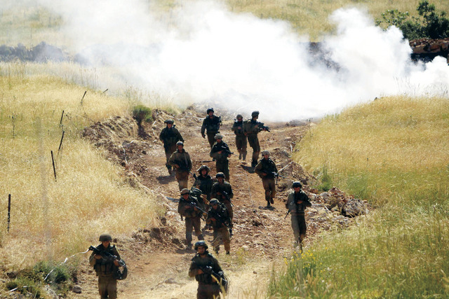 "جنود إسرائيليون يمشطون الحدود الإسرائيلية السورية قرب مجدل شمس في الجولان المحتل (رويترز)"