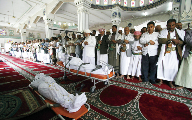 "يمنيون يصلون على جثامين قتلى المعارك في تعز (رويترز)"