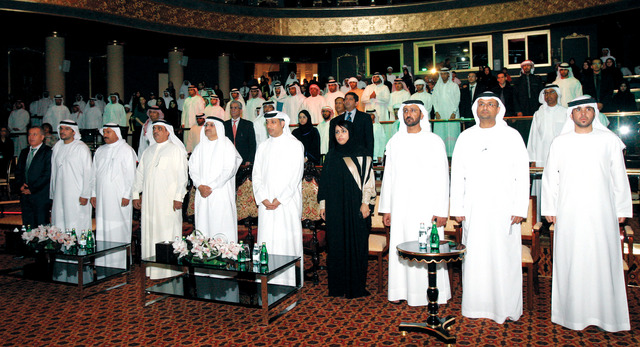 "حميد القطامي ومحمد النعيمي وعدد من كبار المسؤولين خلال تحية السلام الوطني قبل توزيع الجوائز تصوير: زافير"