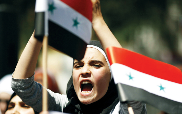 "فتاة سورية خلال اعتصام أمام القنصلية السورية في اسطنبول (رويترز)"