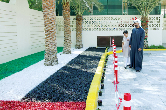 "محمد بن زايد والطالبة اليازية امام علم الامارات"