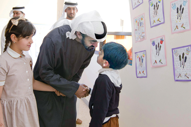 "ولي عهد أبوظبي يصافح احد التلاميذ"