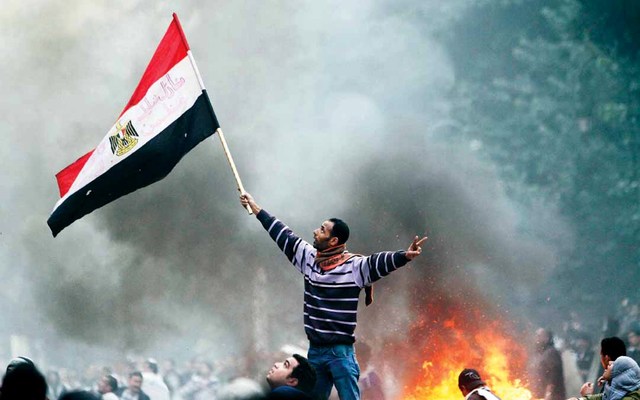 "متظاهر يرفع العلم المصري خارج مبنى البرلمان"