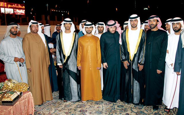 "أحمد ومنصور بن محمد بن راشد آل مكتوم يتوسطان العريسين وعدداً من اقاربهم"