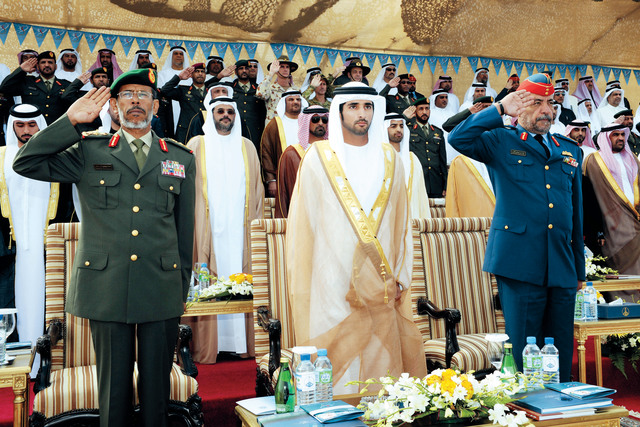 "ولي عهد دبي يتوسط الرميثي والقمزي أثناء أداء السلام الوطني للدولة"