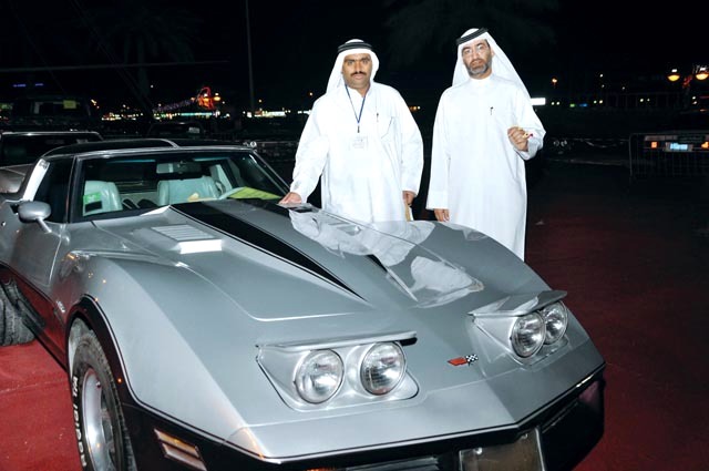 "أنور الهنائي يميناً بجانب إحدى السيارات الكلاسيكية المعروضة"