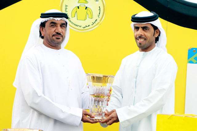 "علي المهيري يتسلم الكأس من عيسى علي"