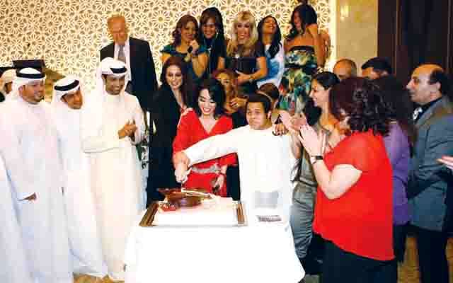 "أريام تتوسط الأصدقاء أثناء تقطيعها لقالب الكيك"