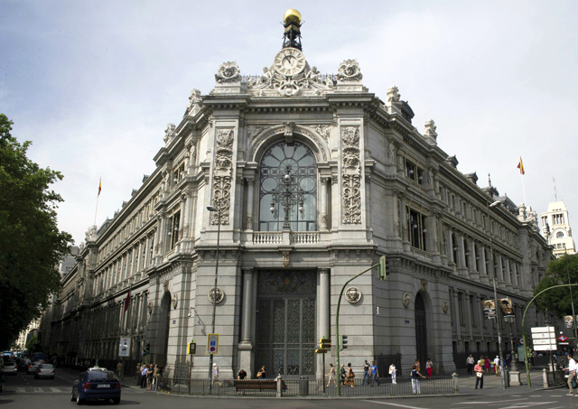 "أشخاص يمرون أمام مقر البنك المركزي في مدريد، حيث يتوقع أن تتقدم إسبانيا بطلب إنقاذ اليوم"