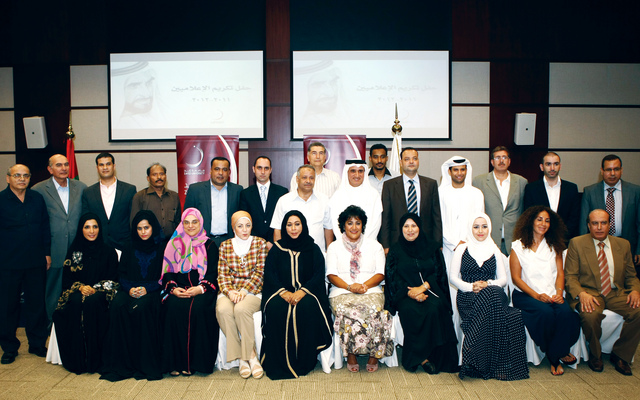 "د. سليمان الجاسم يتوسط الإعلاميين في لقطة تذكارية"