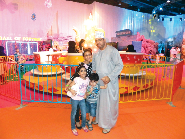 "محمد الكندي وأولاده أمام لعبة الفنجان الدوار \t البيان"