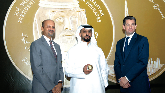 "أحمد وسلطان بن سليم أمام مسكوكة عالمية صنعت في دبي باسم «عملة البليون» الذهبية"