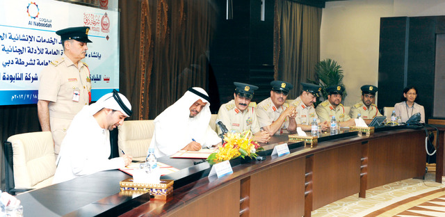 "ضاحي خلفان وسنان النابودة يوقعان على الاتفاقية بحضور المزينة \tمن المصدر"
