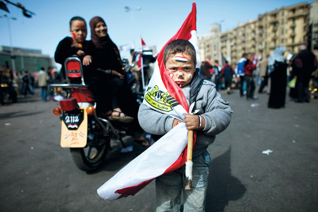 "طفل مصري يلتف بعلم بلاده في ميدان التحرير وسط العاصمة القاهرة \tجتي"