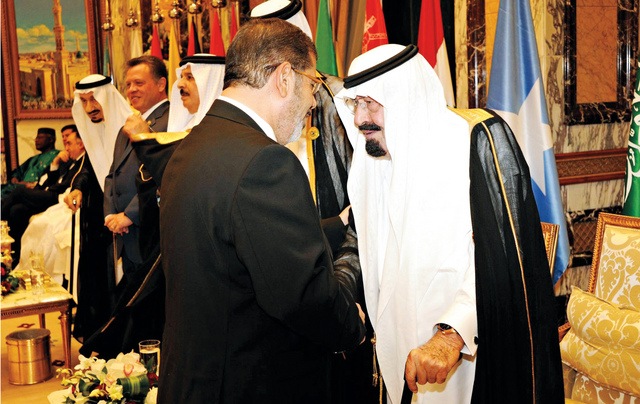 "العاهل السعودي يصافح الرئيس المصري محمد مرسي\tرويترز"