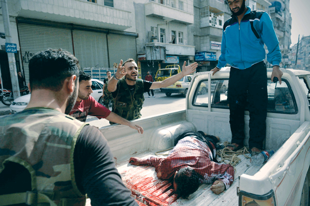 "ثائر من حلب يصرخ طالباً النجدة لإسعاف مدني تذكرته رصاصات جيش الأسد \tا.ف.ب"