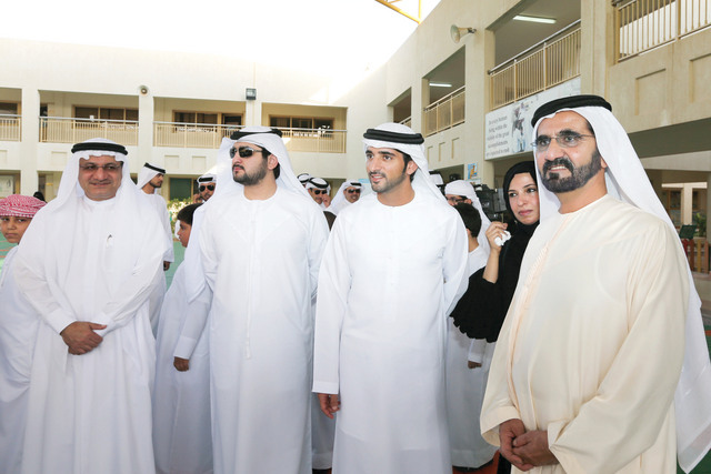 "محمد بن راشد وحمدان ومكتوم بن محمد وحميد القطامي في باحة إحدى المدارس"