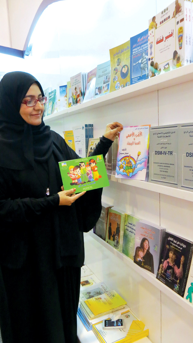 "منى اليافعي بجوار بعض الكتب المتخصصة"