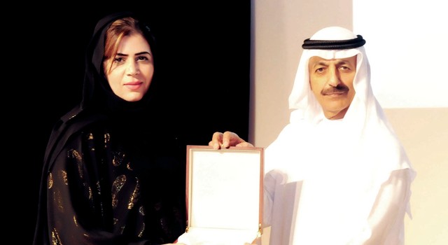 "محمد بن صقر القاسمي يسلم درعاً تذكارية إلى فاطمة بوحجير \tمن المصدر"