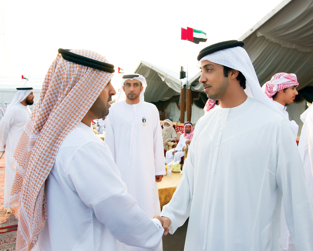 "منصور بن زايد يصافح احد المستقبلين"