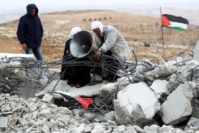 "فلسطينيان يحاولان الابقاء على مكبر الصوت والعلم الفلسطيني فوق انقاض مسجد المفقرة \t\tإي.بي.إيه"