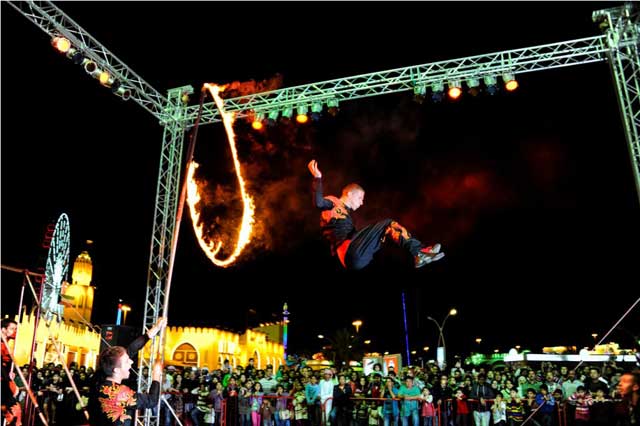 "عارض يقدم فنه لجمهور القرية العالمية وسط انبهار وتصفيق حاد حيث تجسد النيران وبراعة العارض دور الفنون في بهجة الجمهور"