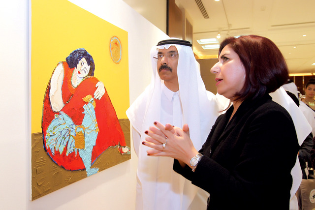 "...وشرح من سلمى المري لإحدى لوحاتها \t تصوير ــ عماد علاء الدين"