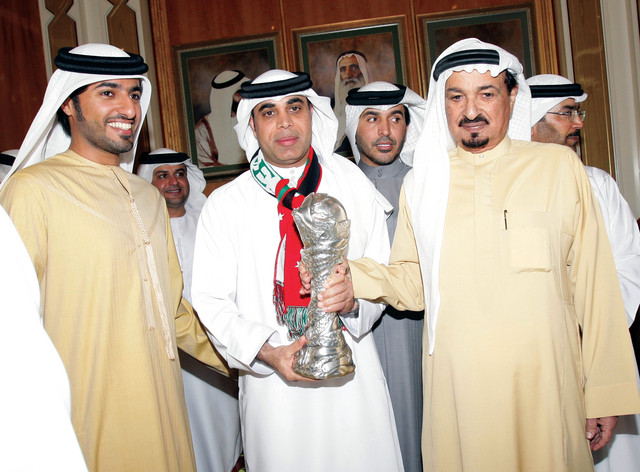 "حميد بن راشد النعيمي وراشد بن حميد يتسلمان الكأس من مهدي علي"