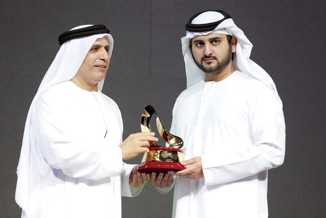 "مكتوم بن محمد يتسلم درعا تذكارية من مطر الطاير\tتصوير ـــ خليفة اليوسف"