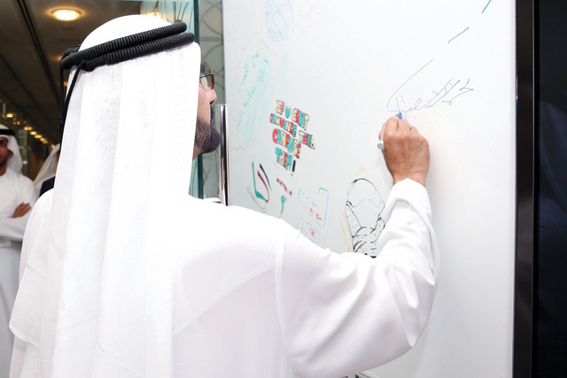 "محمد بن راشد يخط توقيعه على لوحة الموظفين في المكتب التنفيذي"