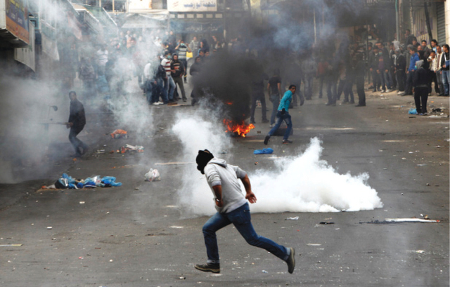 "فلسطينيون وسط قنابل الغاز التي أطلقها جنود الاحتلال خلال احتجاج على استشهاد الأسير عرفات جرادات تحت التعذيب\t\t\t\t رويترز"