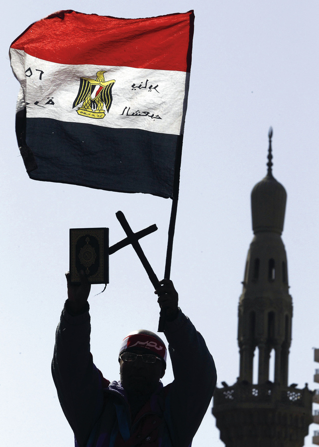 "مناوئ لمرسي رافعاً علم بلاده جنباً إلى جنب مع القرآن والصليب\tرويترز"