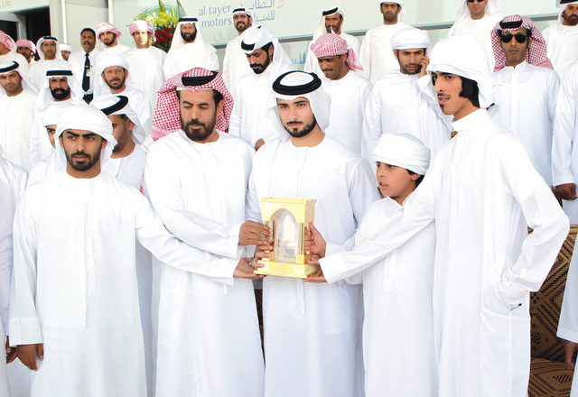 "..ويهدي الدرع التذكارية للفائزين"