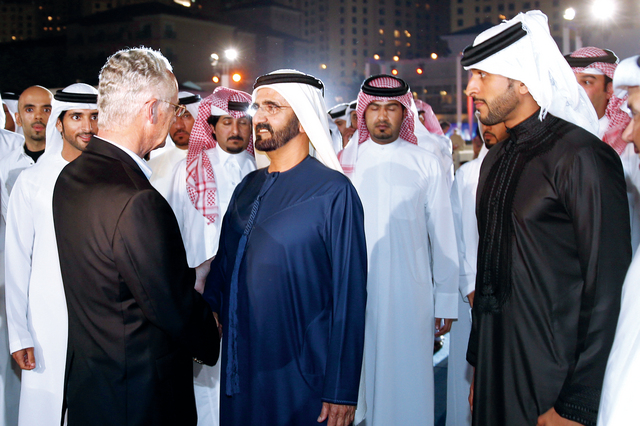 "محمد بن راشد يصافح أحد المشاركين في المهرجان بحضور حمدان بن محمد"