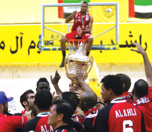 "لاعبو الأهلي يحملون الكأس وطلال سالم يقطع الشبكة تذكاراً للقب"