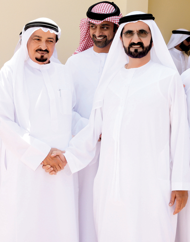 "محمد بن راشد مصافحاً حميد النعيمي بحضور عمار بن حميد"