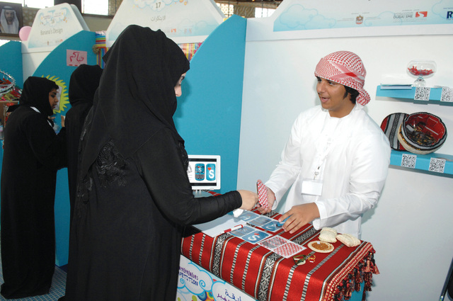 "عبدالله المزروعي يروج لملصقات الهاتف المبتكرة مع الزبائن \tتصوير ـــ حنيف"