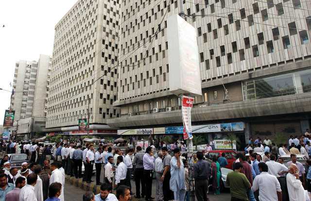 "مدنيون في كراتشي بباكستان يهرعون إلى الشوارع بخوف ابتعاداً عن البنايات خلال حدوث الزلزال \t إي.بي.أيه"