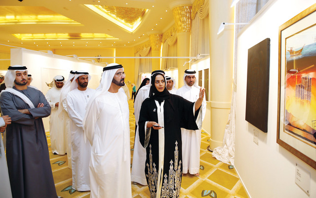 "محمد بن راشد يستمع الى شرح عن احدى اللوحات بحضور ماجد بن محمد وعيسى الميدور\tتصوير- سيف محمد"
