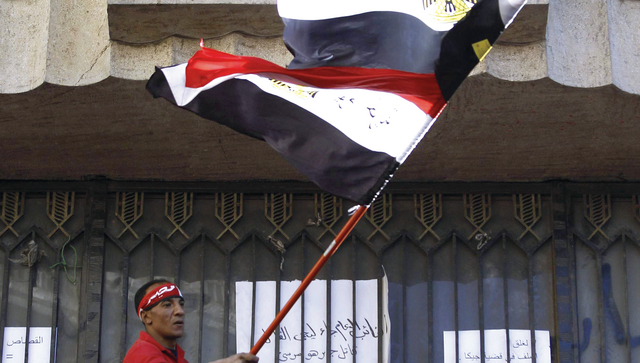 "مصري ممسكاً بعلم بلاده خلال تظاهرة مناوئة لمرسي في محيط دار القضاء \tرويترز"