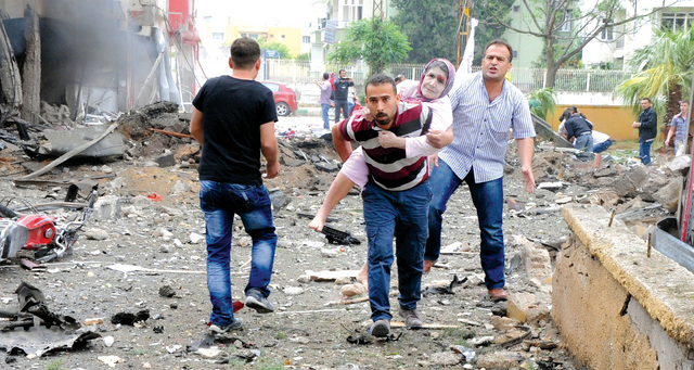 "مسعف يحاول إنقاذ امرأة تركية مسنة أصيبت في أحد التفجيرين في الريحانية \t أ.ف.ب"