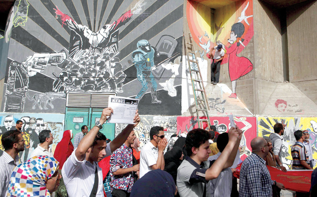 "تظاهرات مناهضة لمرسي وجماعة الإخوان تسير إلى جوار جدارية قرب ميدان التحرير رويترز"