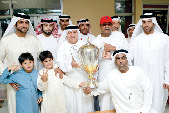 "عبدالملك محتفياً بالكأس مع الأسرة الأهلاوية \tتصوير  - سالم خميس"